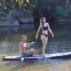 Pareja sobre tabla paddle surf hinchable Behumax Caribbean en aguas tranquilas