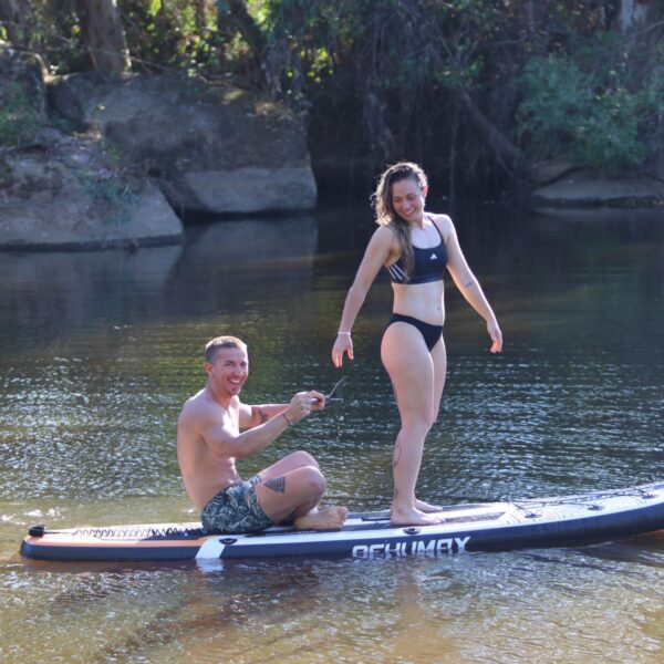 Pareja sobre tabla paddle surf hinchable Behumax Caribbean en aguas tranquilas
