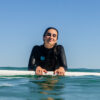 chica con neopreno y tabla de surf