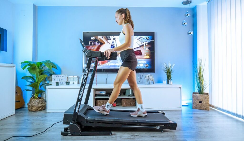 Mujer caminando en la cinta de correr Treadmill Active 4100 para volver a la rutina de cardio en casa