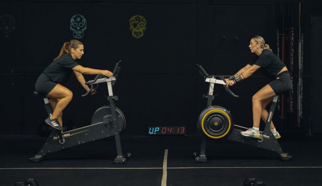 mujeres entrenando en air bike hero